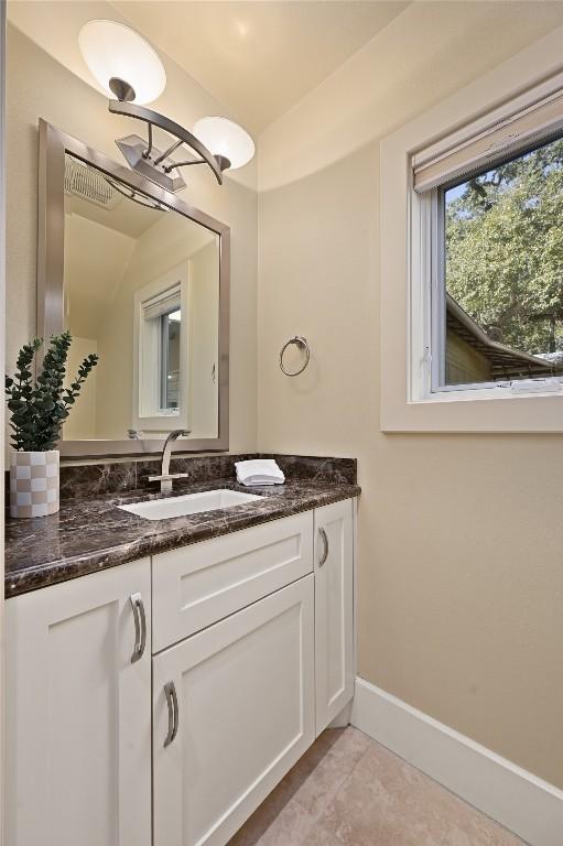 bathroom with tile patterned flooring, vanity, and baseboards