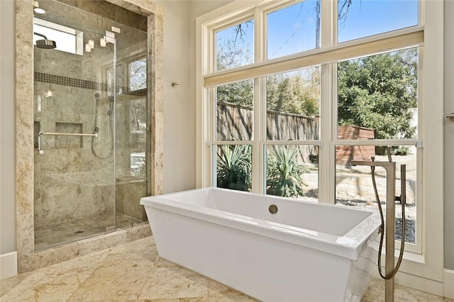 full bath featuring a freestanding tub and a shower stall