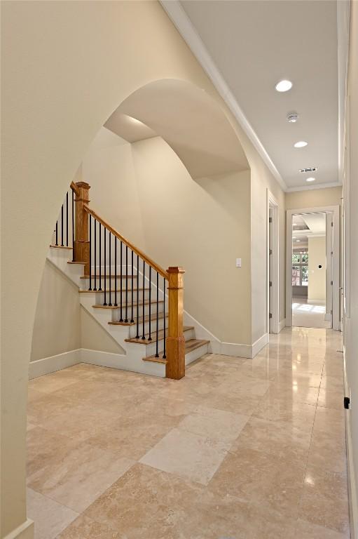 staircase with baseboards, arched walkways, ornamental molding, marble finish floor, and recessed lighting