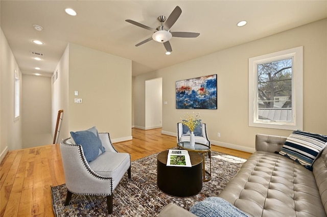 living room featuring baseboards, visible vents, wood finished floors, and recessed lighting