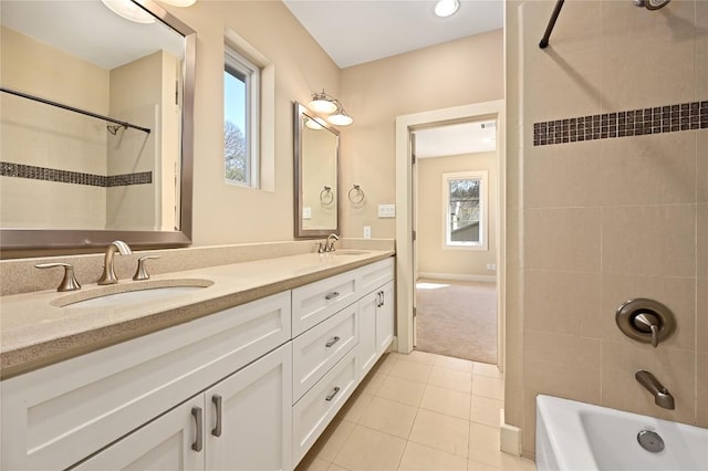 bathroom with double vanity, shower / bathing tub combination, tile patterned flooring, and a sink