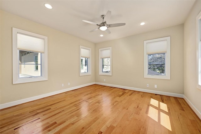 empty room with baseboards, recessed lighting, light wood-type flooring, and a healthy amount of sunlight