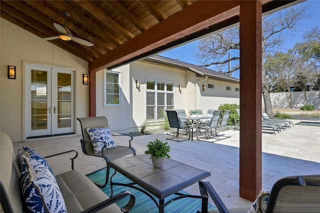 view of patio / terrace with french doors, fence, outdoor dining area, and ceiling fan