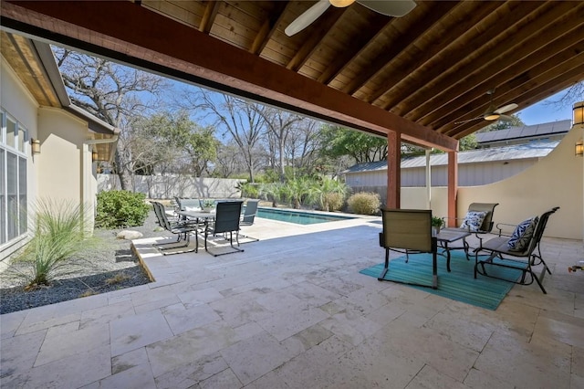 view of patio featuring ceiling fan, outdoor dining area, a fenced backyard, and a fenced in pool