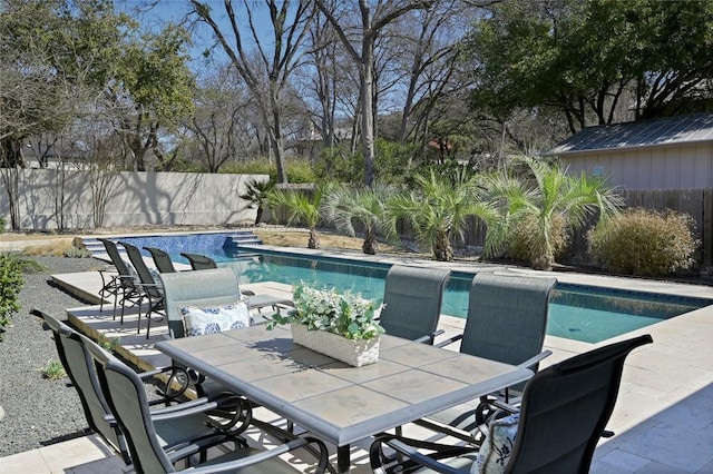 view of pool with a fenced in pool, a patio area, outdoor dining area, and a fenced backyard