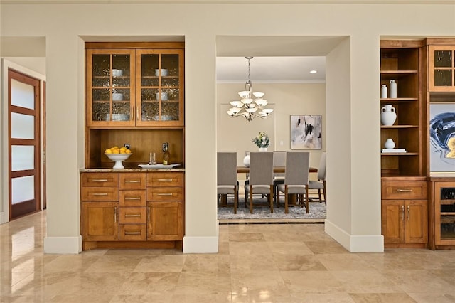 bar with ornamental molding, baseboards, and an inviting chandelier