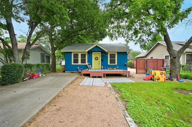 bungalow-style house featuring an outbuilding, a playground, and a front lawn