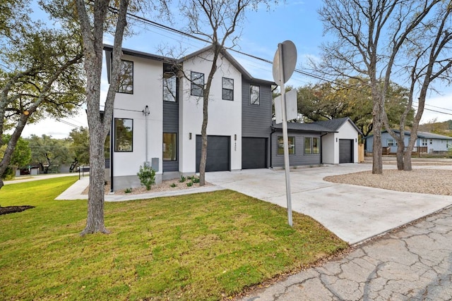 view of front of home with driveway, stucco siding, an attached garage, and a front yard