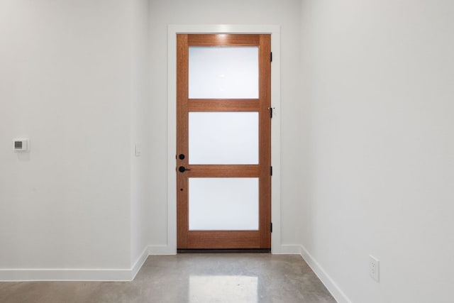 doorway to outside with finished concrete floors and baseboards