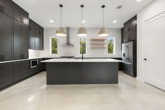 kitchen featuring visible vents, appliances with stainless steel finishes, a sink, wall chimney range hood, and concrete flooring