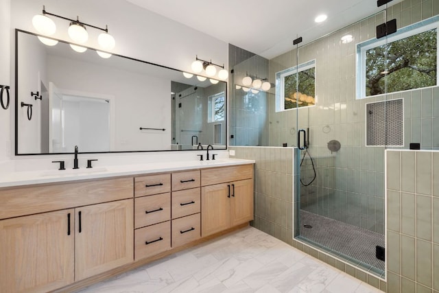 bathroom with marble finish floor, double vanity, a sink, and a shower stall