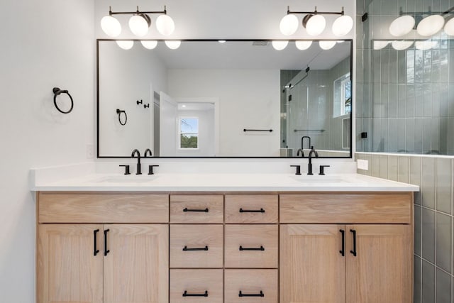 full bathroom featuring double vanity, a shower stall, and a sink