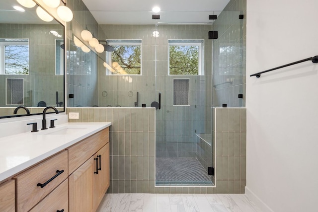 bathroom featuring marble finish floor, a shower stall, and vanity