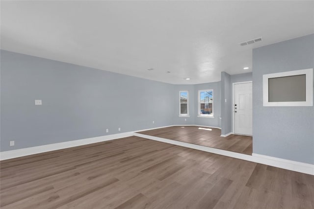 interior space featuring baseboards, visible vents, and wood finished floors