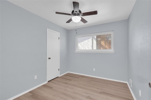 empty room featuring ceiling fan, baseboards, and wood finished floors