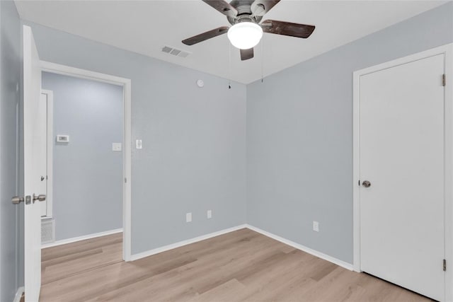 unfurnished room featuring baseboards, visible vents, ceiling fan, and light wood finished floors