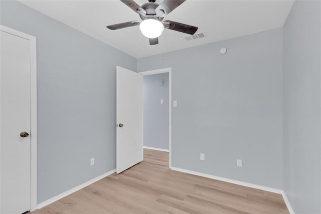 empty room with a ceiling fan, baseboards, visible vents, and wood finished floors