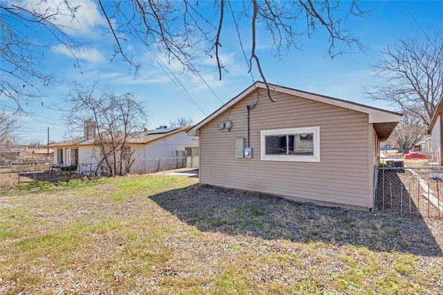 back of property with fence and a lawn