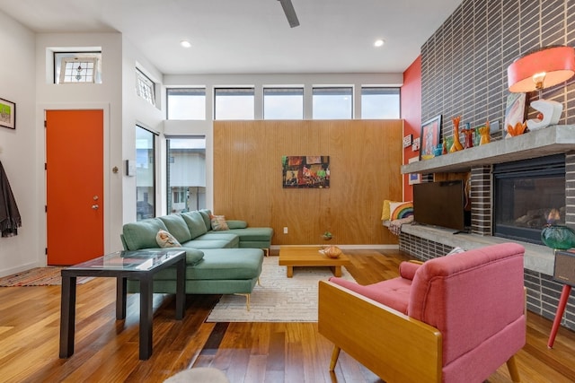 living room with a fireplace, a high ceiling, and wood finished floors