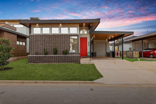 contemporary home with a front lawn, an attached carport, and concrete driveway