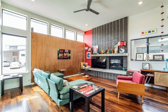 living room featuring recessed lighting, plenty of natural light, hardwood / wood-style floors, and a tile fireplace