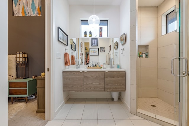 bathroom with a shower stall, baseboards, tile patterned flooring, and vanity