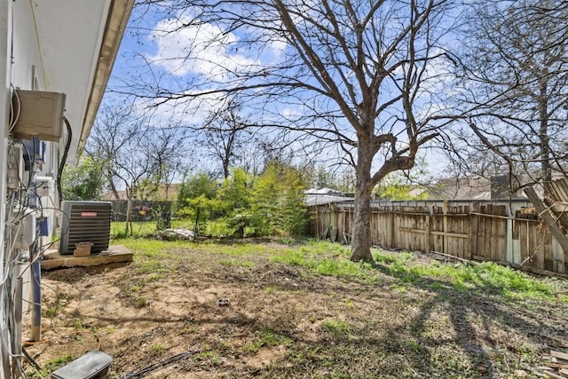 view of yard with a fenced backyard and central AC