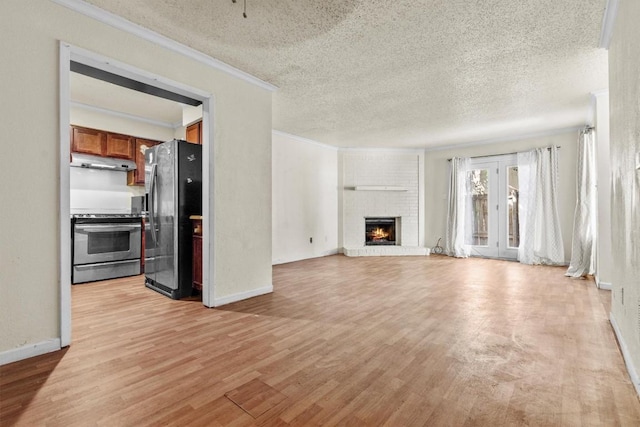 unfurnished living room featuring baseboards, crown molding, a textured ceiling, light wood-style floors, and a fireplace