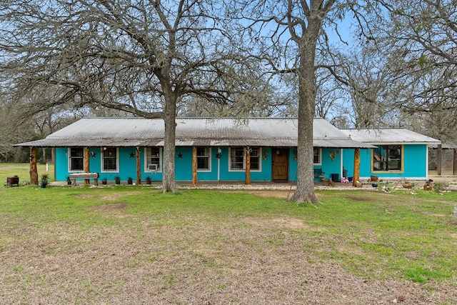 view of front facade with a porch, metal roof, and a front lawn