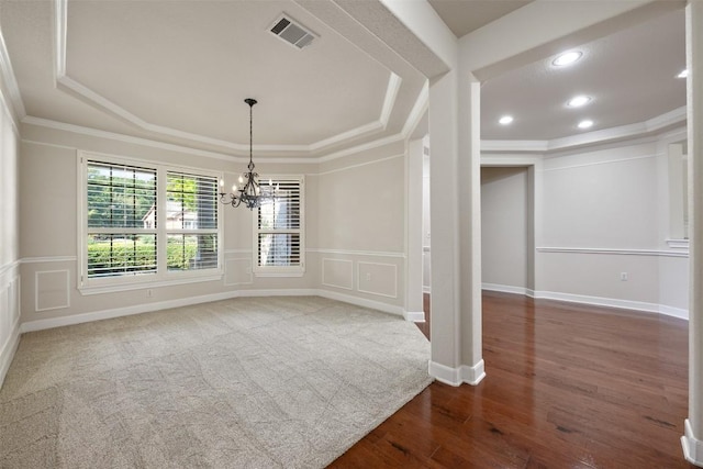 interior space featuring crown molding, a tray ceiling, visible vents, and a decorative wall