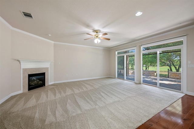 unfurnished living room featuring a fireplace, visible vents, crown molding, and baseboards