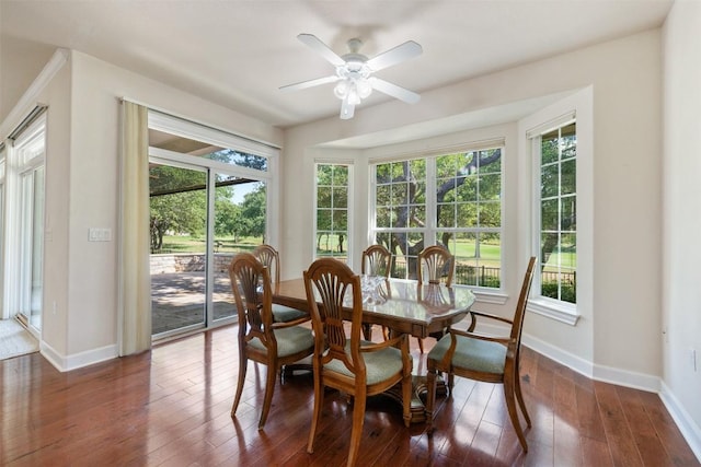 dining space with dark wood-style floors, ceiling fan, and baseboards