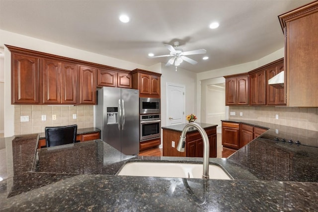 kitchen with tasteful backsplash, a ceiling fan, dark stone countertops, stainless steel appliances, and a sink