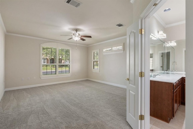 empty room with ornamental molding, light colored carpet, visible vents, and baseboards