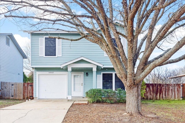 view of front of home featuring a garage, fence, and driveway