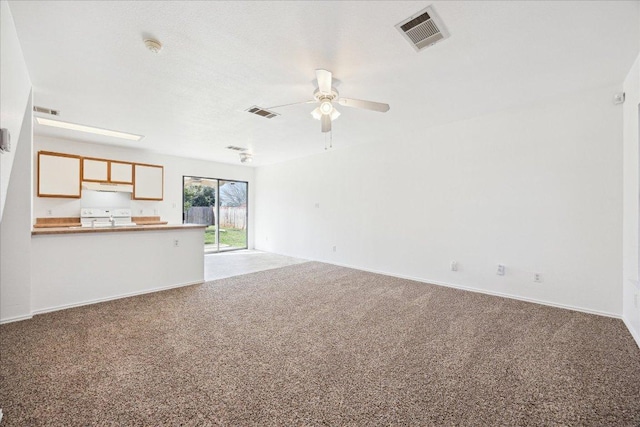 unfurnished living room with carpet, visible vents, and ceiling fan