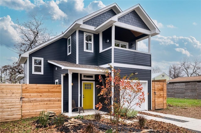 view of front of property featuring a garage, fence, and a balcony