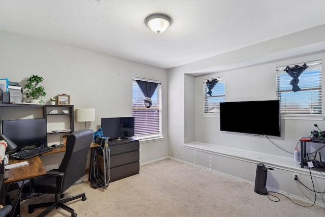 carpeted office space with a textured ceiling and baseboards