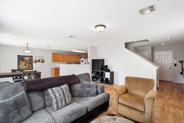 living area featuring light wood-style floors and visible vents