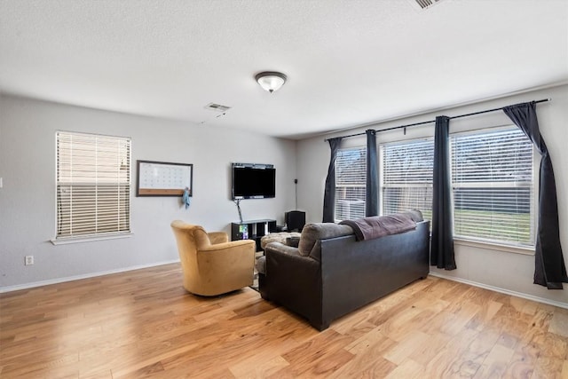 2112 Perkins Pl, Georgetown, TX 78626 - living room featuring light wood-type flooring, baseboards, and a textured ceiling