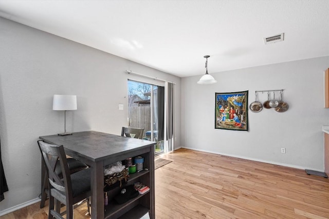 dining space with baseboards, visible vents, and light wood-style floors