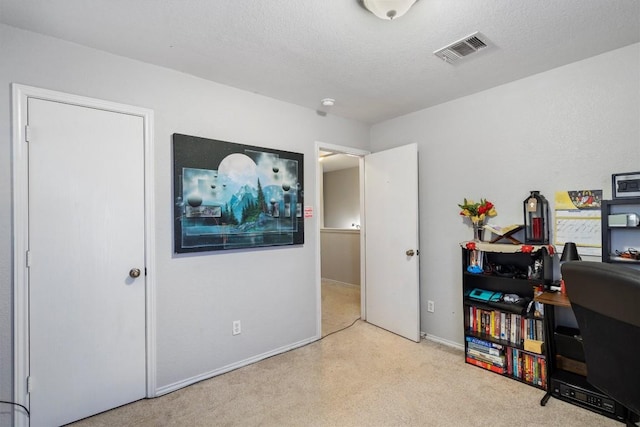 office area featuring a textured ceiling, carpet flooring, and visible vents