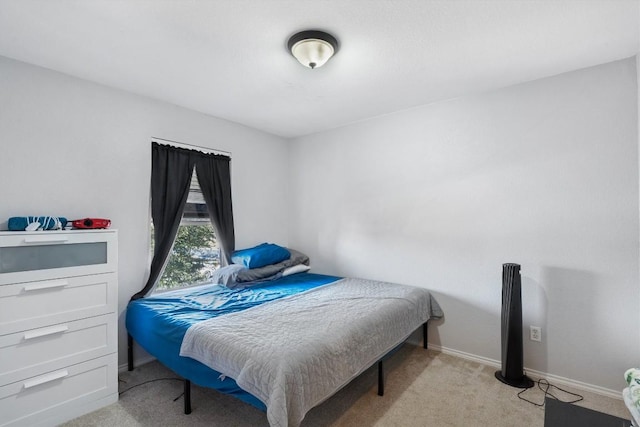 bedroom with light colored carpet and baseboards