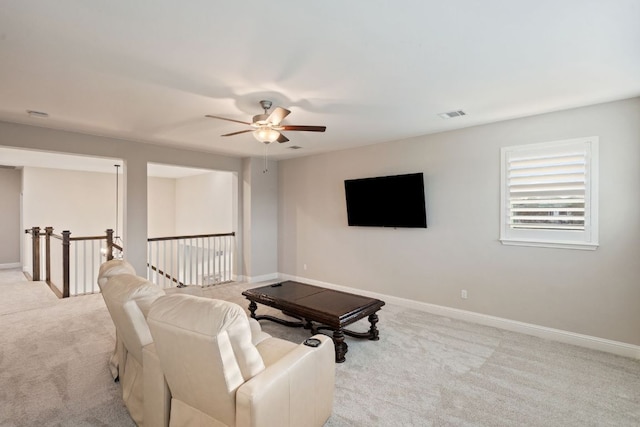 living area with a ceiling fan, visible vents, baseboards, and carpet flooring