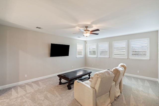 living area with a ceiling fan, light colored carpet, visible vents, and baseboards