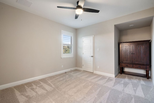 unfurnished bedroom with visible vents, baseboards, ceiling fan, and light colored carpet