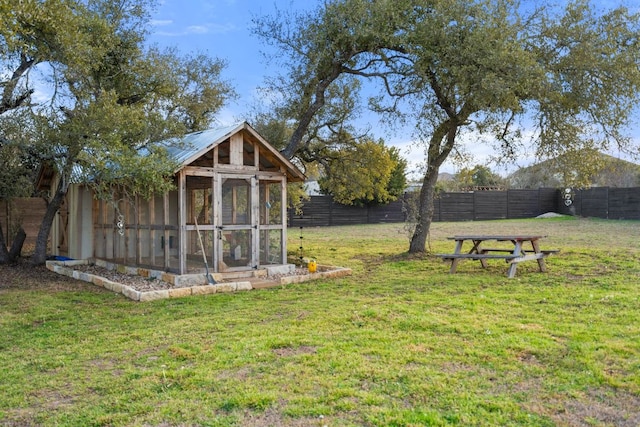 view of yard with an outbuilding, a fenced backyard, and exterior structure