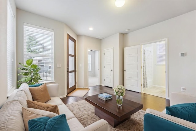 living room with baseboards, wood finished floors, and recessed lighting