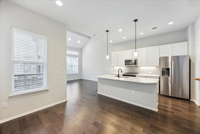 10204 Jacksboro Trl, Austin, TX 78717 - kitchen featuring appliances with stainless steel finishes, tasteful backsplash, a sink, dark wood-type flooring, and light countertops