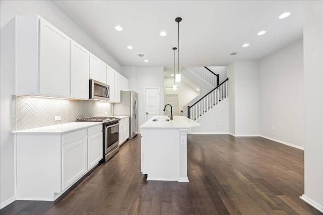 10204 Jacksboro Trl, Austin, TX 78717 - kitchen with stainless steel appliances, dark wood finished floors, a sink, a center island with sink, and recessed lighting